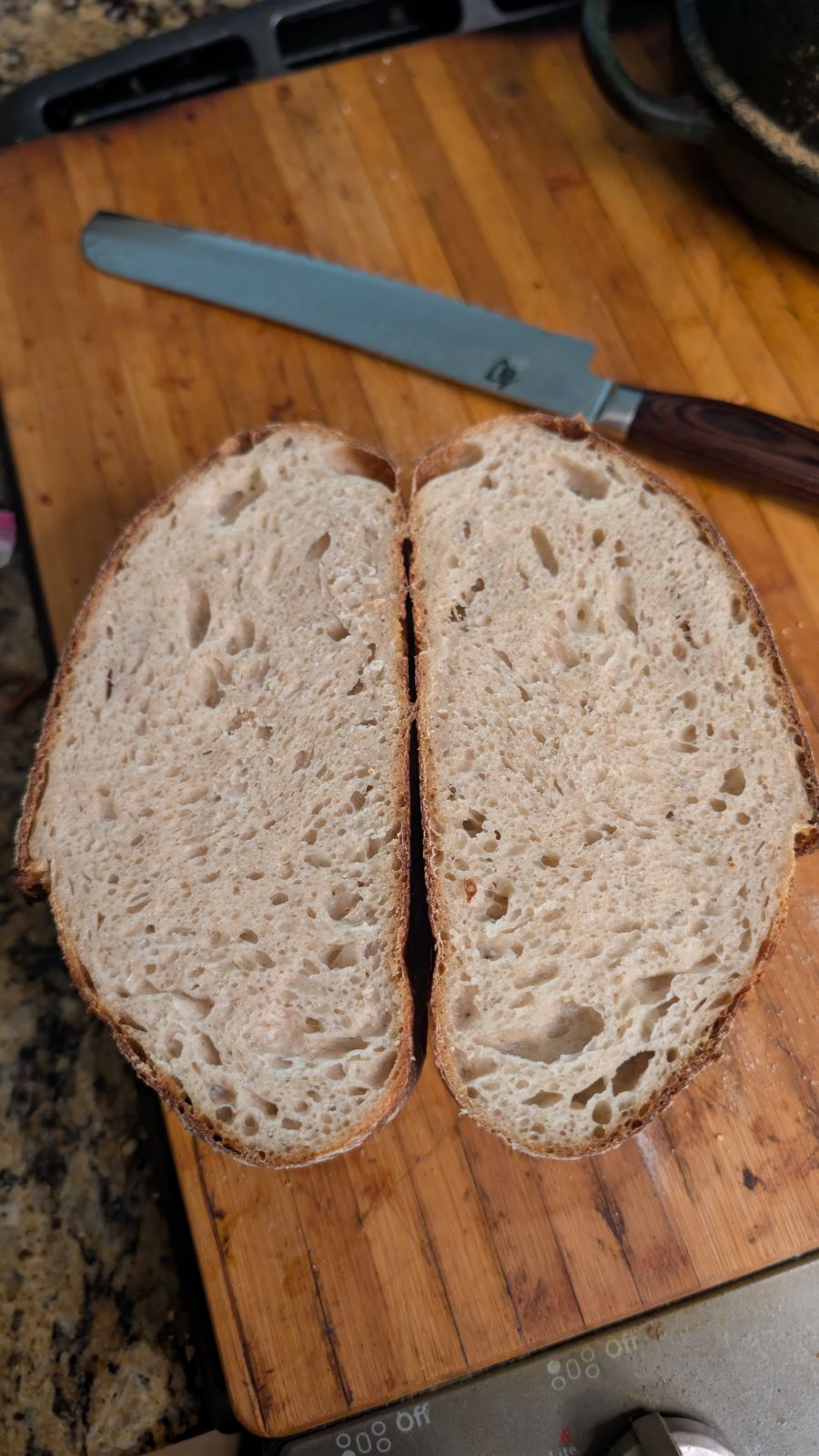 Sliced second sourdough boule showing an open crumb with large irregular holes