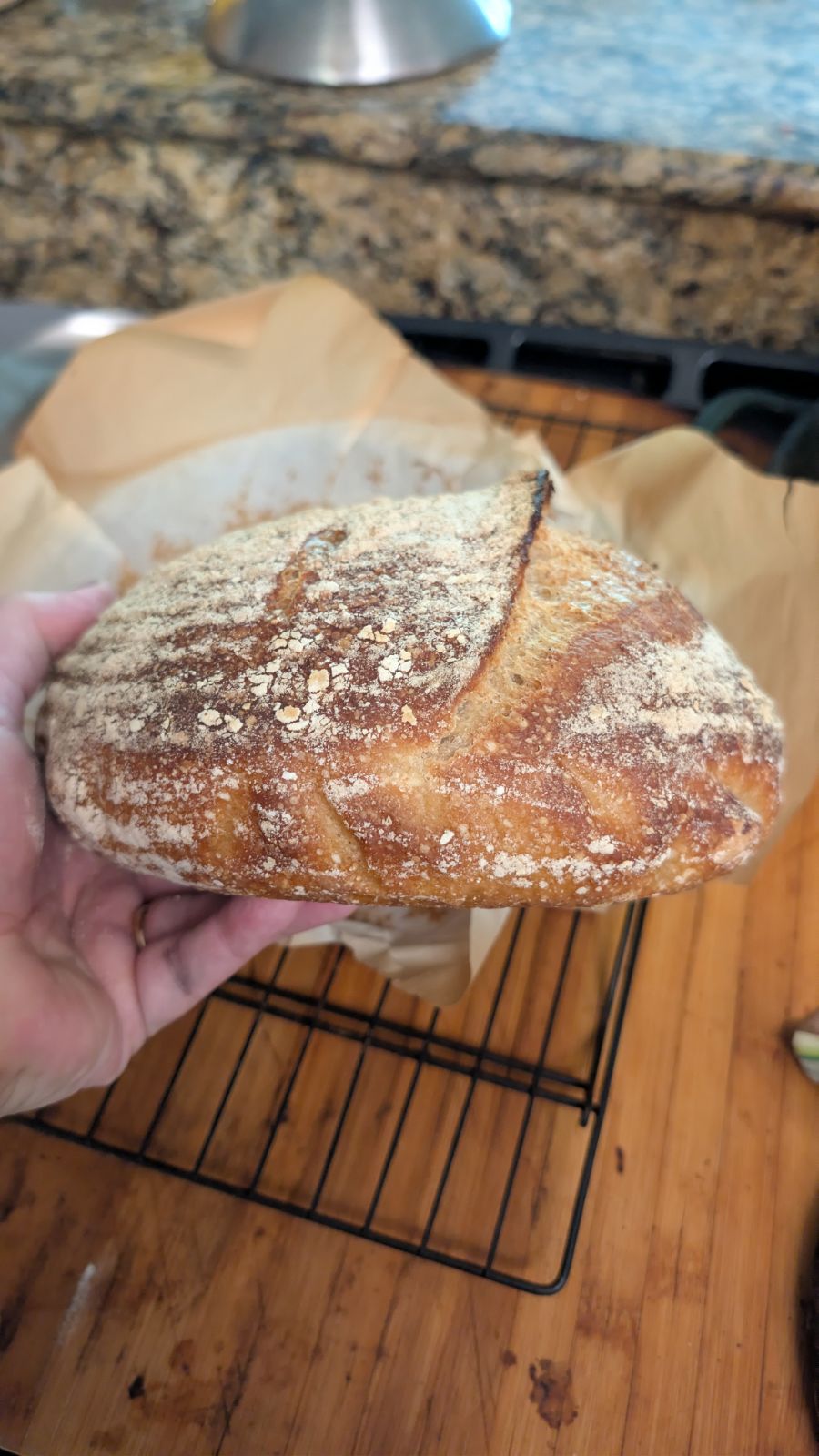 Freshly baked sourdough boule with a deeply golden crust on a cooling rack